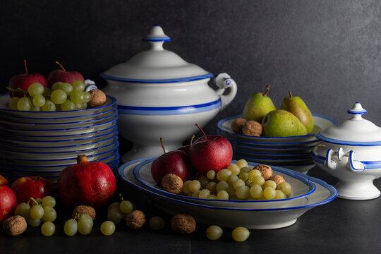 Still life arrangement displaying fresh fruit and classic tableware