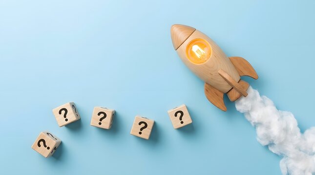 A wooden rocket ship taking off into the air leaving behind several small wooden blocks with question marks printed on them