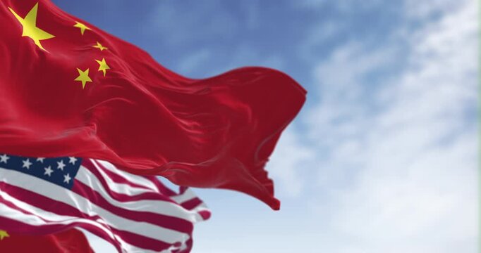 Chinese and American flags waving together against blue sky. 3D render