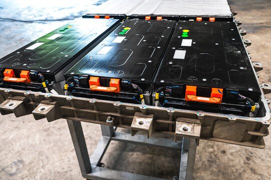 EV car battery pack lying on workbench in modern auto service center, ready for technical diagnosis and servicing