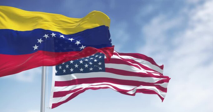 Venezuela and US national flags waving in the wind on a clear day