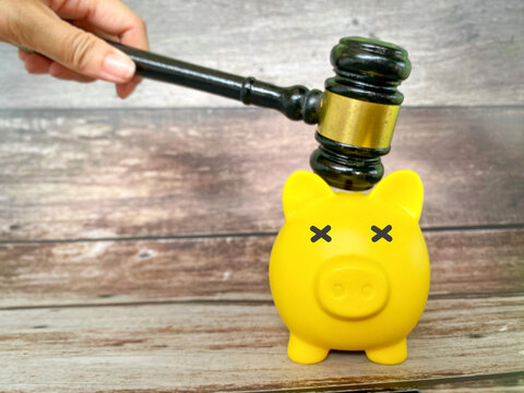 Judge Gavel Striking Piggy Bank Symbolizing Financial Penalty and Legal Action