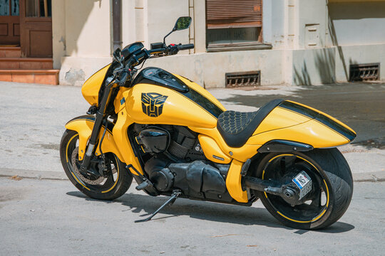 June 7, 2026, Sremski Karlovci, Serbia: Custom yellow cruiser motorcycle with Autobot insignia parked on urban street