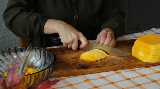 Female hands cutting pumpkin. Cooking pumpkin soup or cake.