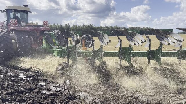 Modern tractor pulling a plow while working in the field. Realistic agricultural scene showing soil tillage, powerful machinery, and efficient land preparation.