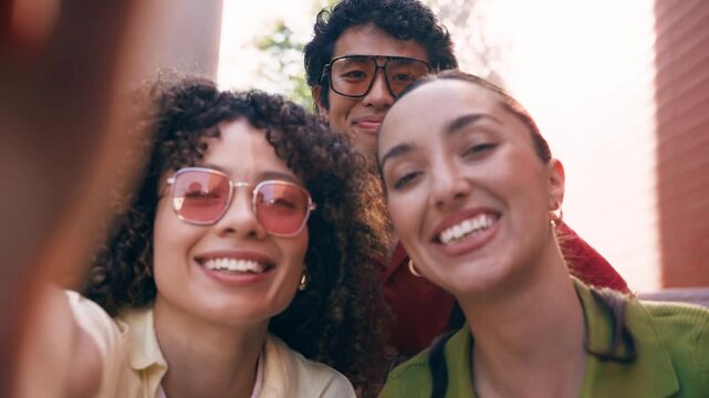 Video of three friends taking selfie with smartphone while sitting on the street