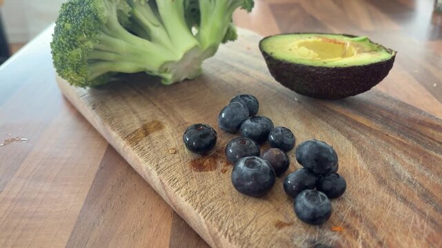 Healthy Food Ingredients with Avocado, Blueberries and Broccoli on Wooden Table