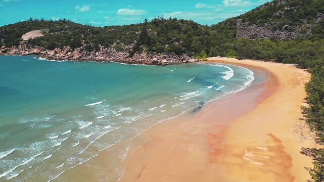 Cinematic arial footage of a tropical paradise. Empty beach and turquoise water. Magnetic Island, Australia.