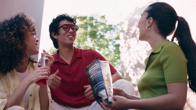 Video of three friends having fun while eating popcorns on the street