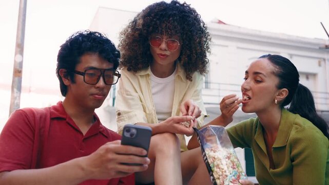 Video of three friends talking while using smartphone on the street