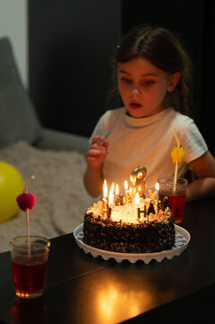 Celebrating a joyful birthday with cake, candles, and laughter in a cozy living room atmosphere during a family gathering at night
