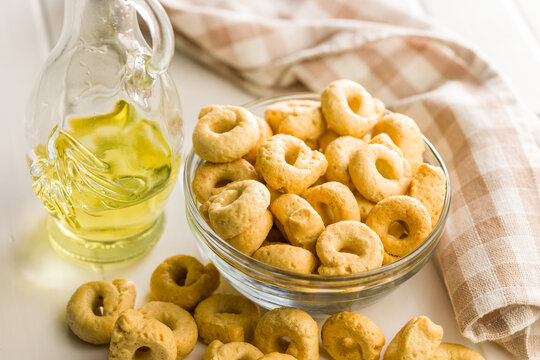 Taralli Italian Crackers With Olive Oil in Bowl On Kitchen Table Rustic Savory Snack
