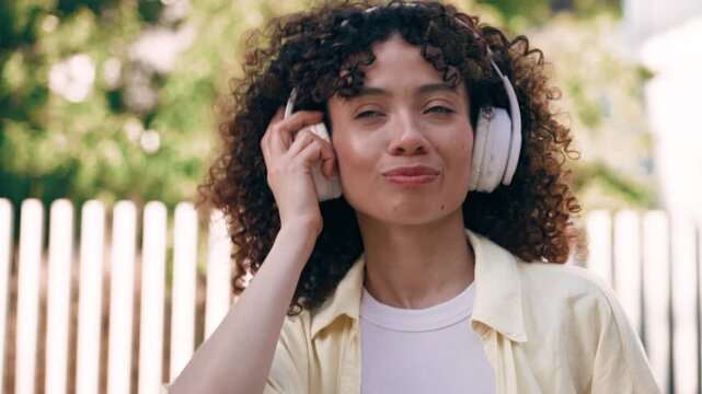 Video of beautiful woman listening music with headphones on the street