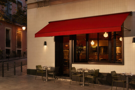 Contemporary restaurant exterior with a red awning at night