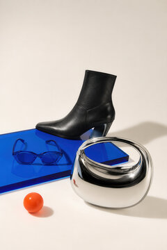 Black ankle boot and blue accessories in a modern fashion still life