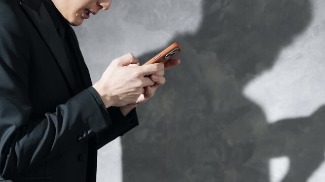 スマホを使う男性とシルエット。悩む, トラブル, 問題, 焦る, 困る, 疑問, シリアス, 犯罪