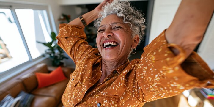 Elderly woman dancing joyfully in her home.