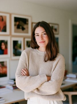 Woman in Sweater, Arms Crossed, Indoor Setting with Framed Photos