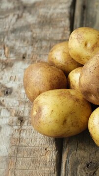 Vertical video. Pile of Raw Potatoes on a Wooden Background