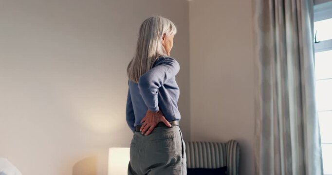 Senior, woman and bed with back pain for muscle tension, discomfort or injury in retirement home. Elderly, female person or sore spine with ache for fibromyalgia, joint inflammation or arthritis