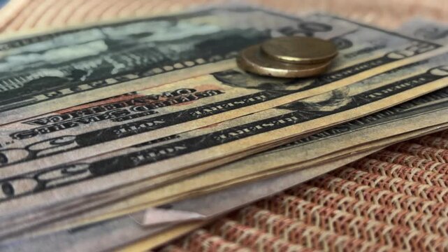 Close up of euro coins falling onto a stack of fifty american dollar bills representing currency exchange rates, global finance, and international business transactions