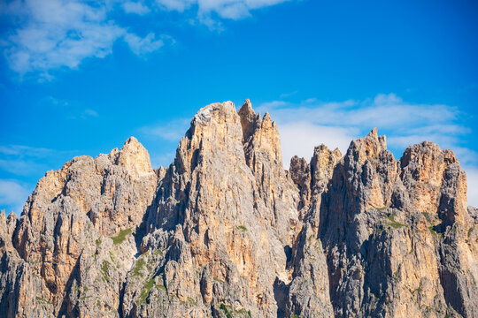 Close-up view of rugged Ciampedie limestone towers of the Dolomite Mountains illuminated by bright summer sunlight beneath a clear blue sky
