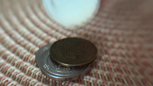 Woman's hand stacking various international coins, showcasing concepts of savings, global finance, personal budget, investment, and wealth accumulation