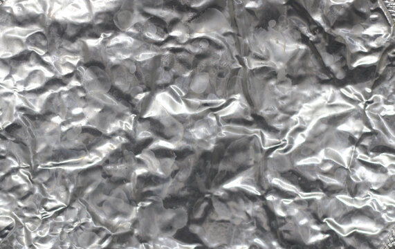 Silver crumpled foil abstract texture background pattern