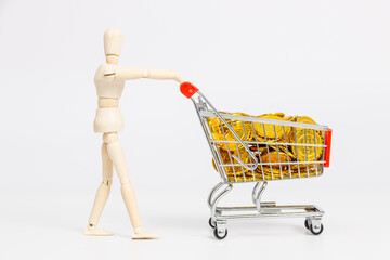 Wooden mannequin pushing shopping cart full of gold coins © PhamHong