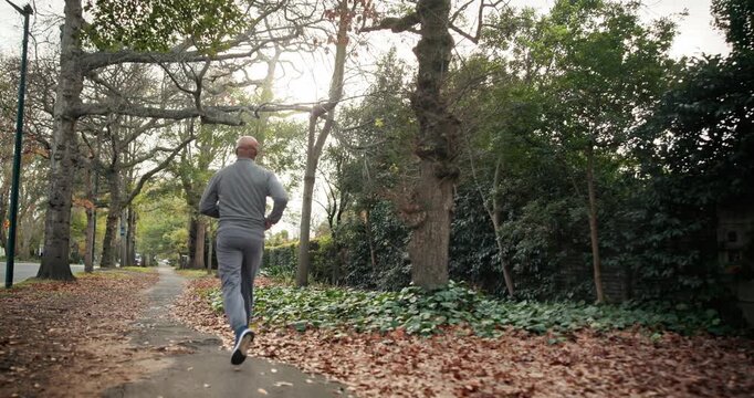 Exercise, fitness and man on road, running and endurance for physical activity or active for health. Outdoor, runner and mature person with energy for cardio, back and workout for wellness in city