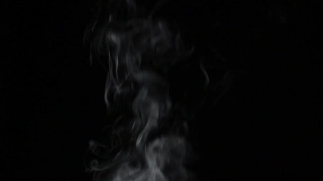 Abstract white steam or smoke rising against black background in static shot
