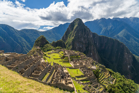 Ancient stone ruins of the Inca citadel Machu Picchu sprawling across a mountain ridge beneath Huayna Picchu peak in the Peruvian Andes