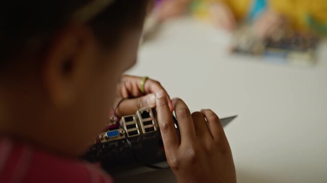 African American child connecting cable to motherboard during STEM class. Footage is ideal for promoting elementary school science, technology, engineering, and math programs