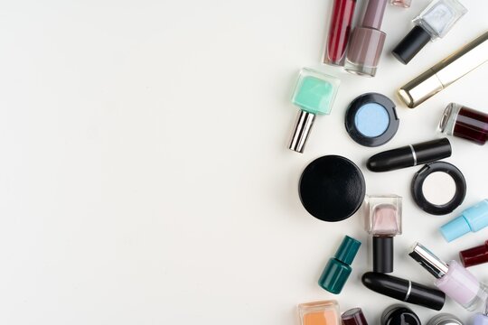 Assorted makeup products scattered on a clean white background.