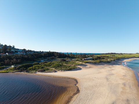 Aerial view of Dee Why Beach and lagoon with coastal vegetation and residential houses on the hillside in Dee Why, New South Wales, Australia.