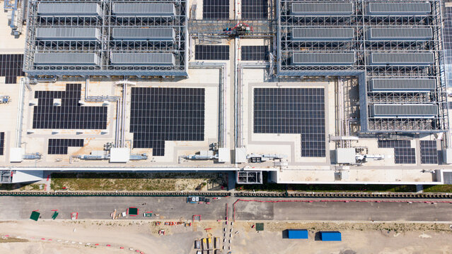 Aerial view of Vantage Data Centre - MXP1 featuring extensive rooftop solar panel arrays and industrial cooling infrastructure in Melegnano, Lombardia, Italy.