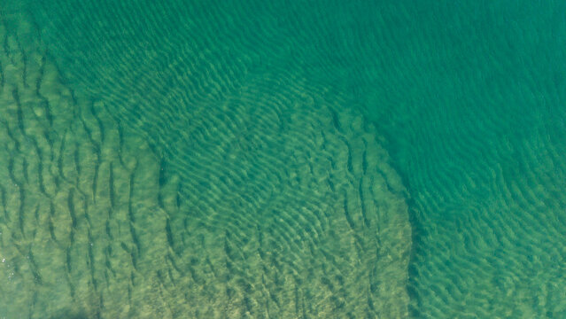 Aerial view of the clear turquoise water and sand ripples on the seabed at Dee Why, New South Wales, Australia.