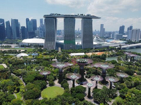Aerial view of Marina Bay Sands and the Supertree Grove at Gardens by the Bay, featuring modern architecture, lush parkland, and the city skyline in Singapore, Singapore, Singapore.