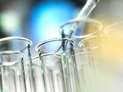 Scientist pipetting a sample into a test tube during a experiment in the laboratory