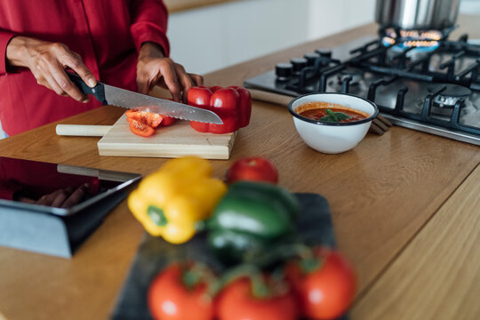 Hands of a woman, chopping bell peppers on a chopping board