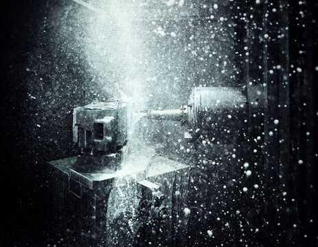 CNC machine drilling into cylinder head with coolant