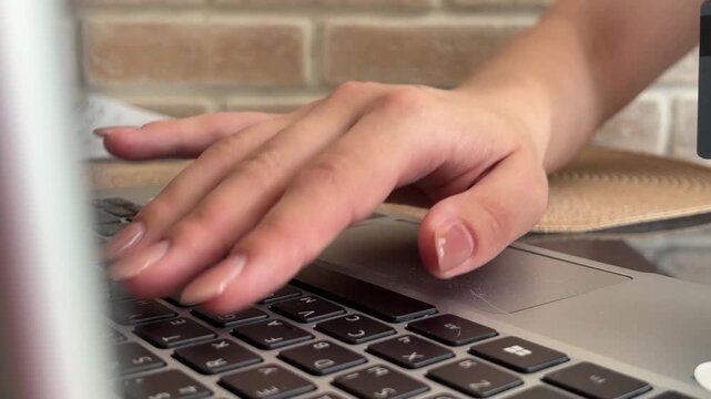 Close up of female hands typing on a laptop keyboard, representing a businesswoman, student, or freelancer working online, studying, or communicating from a home office