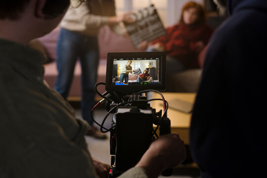 A camera operator films an actress and a crew member on set