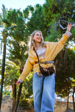 Solo female traveler, joyful vacation moment in sunny historic park with palm trees, authentic city escape, sightseeing, leisure travel and destination exploration