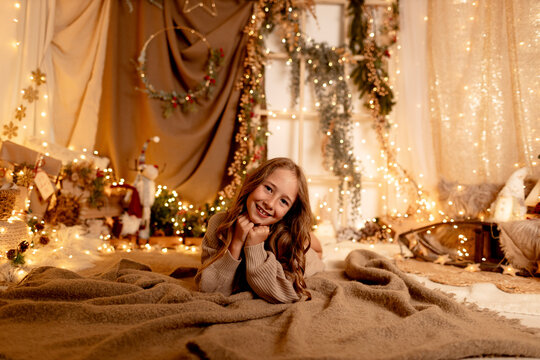 Smiling model lying on blanket in cozy indoor Christmas setting