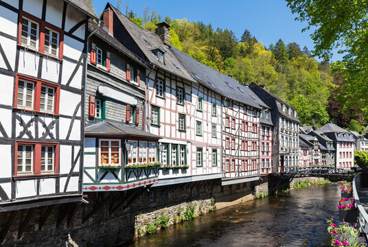 Germany, North Rhine-Westphalia, Monschau, Row of historic half-timbered townhouses standing along Rur river canal in spring