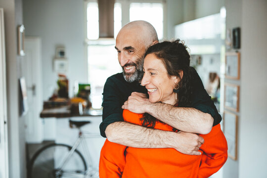 Happy man embracing woman at home