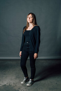 Woman in black casuals standing in front of gray backdrop