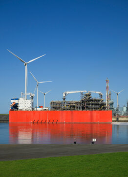 A red LNG terminal floats in the harbor of Eemshaven during the day