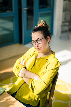 Portrait of young freelancer sitting at desk in her studio